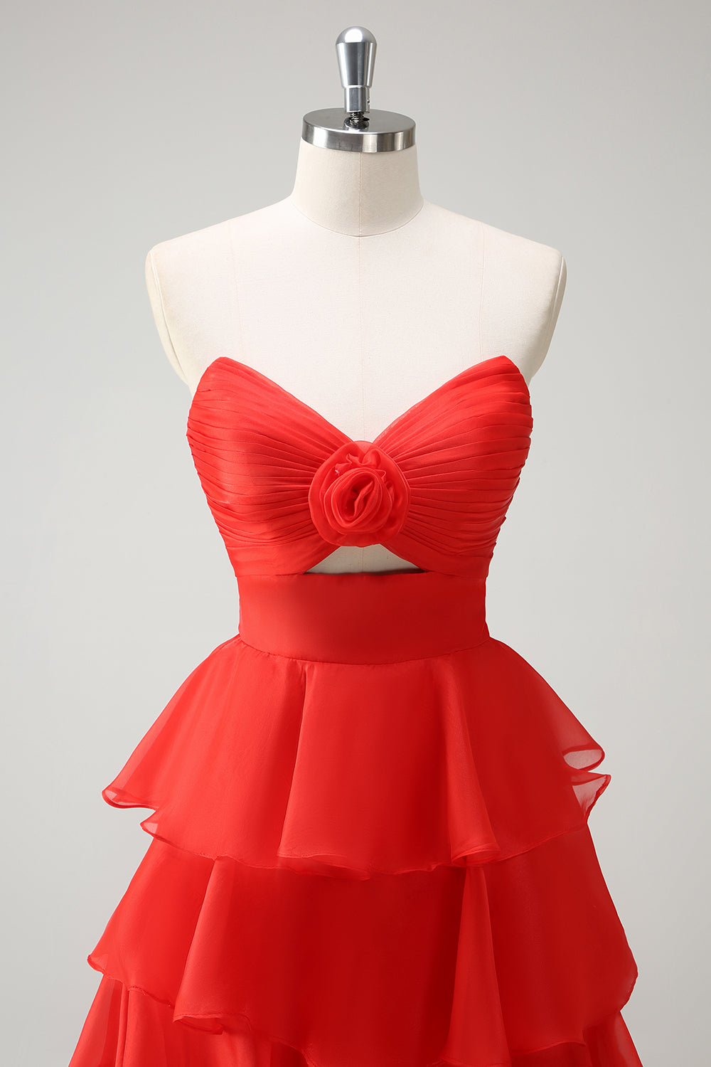 Robe de bal longue orange à volants et décolleté cœur, fendue.