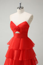 Robe de bal longue orange à volants et décolleté cœur, fendue.
