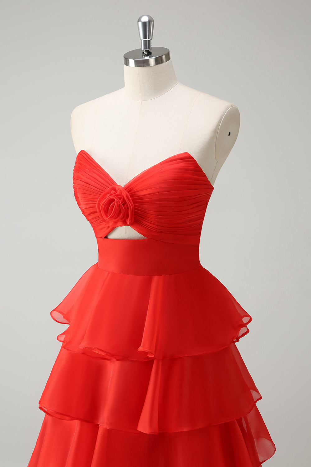 Robe de bal longue orange à volants et décolleté cœur, fendue.