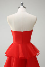 Robe de bal longue orange à volants et décolleté cœur, fendue.