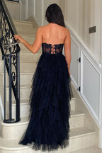Robe de bal longue bustier en tulle rose poudré, coupe trapèze, à volants et corset orné d'appliques