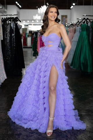 Robe de bal longue lilas en tulle à volants, coupe trapèze, décolleté cœur et fente.