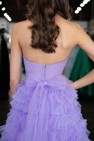 Robe de bal longue lilas en tulle à volants, coupe trapèze, décolleté cœur et fente.