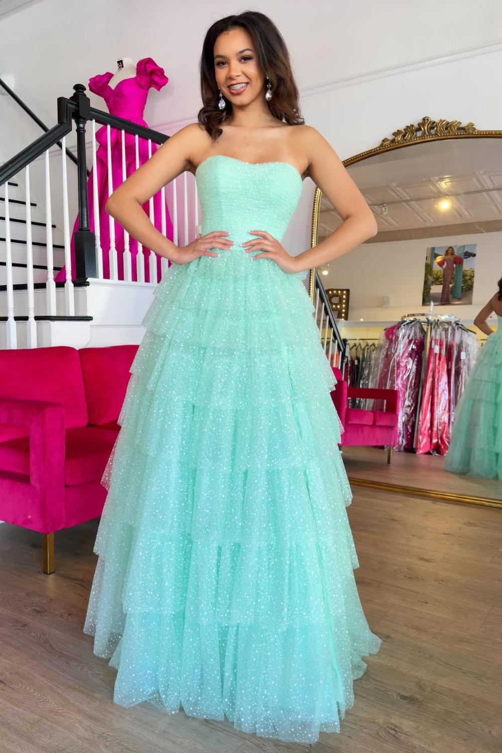 Robe de bal longue trapèze en tulle à volants et décolleté cœur, avec fente.