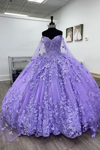 Vestido de quinceañera de tul con capa, tirantes finos y estilo baile, con apliques.