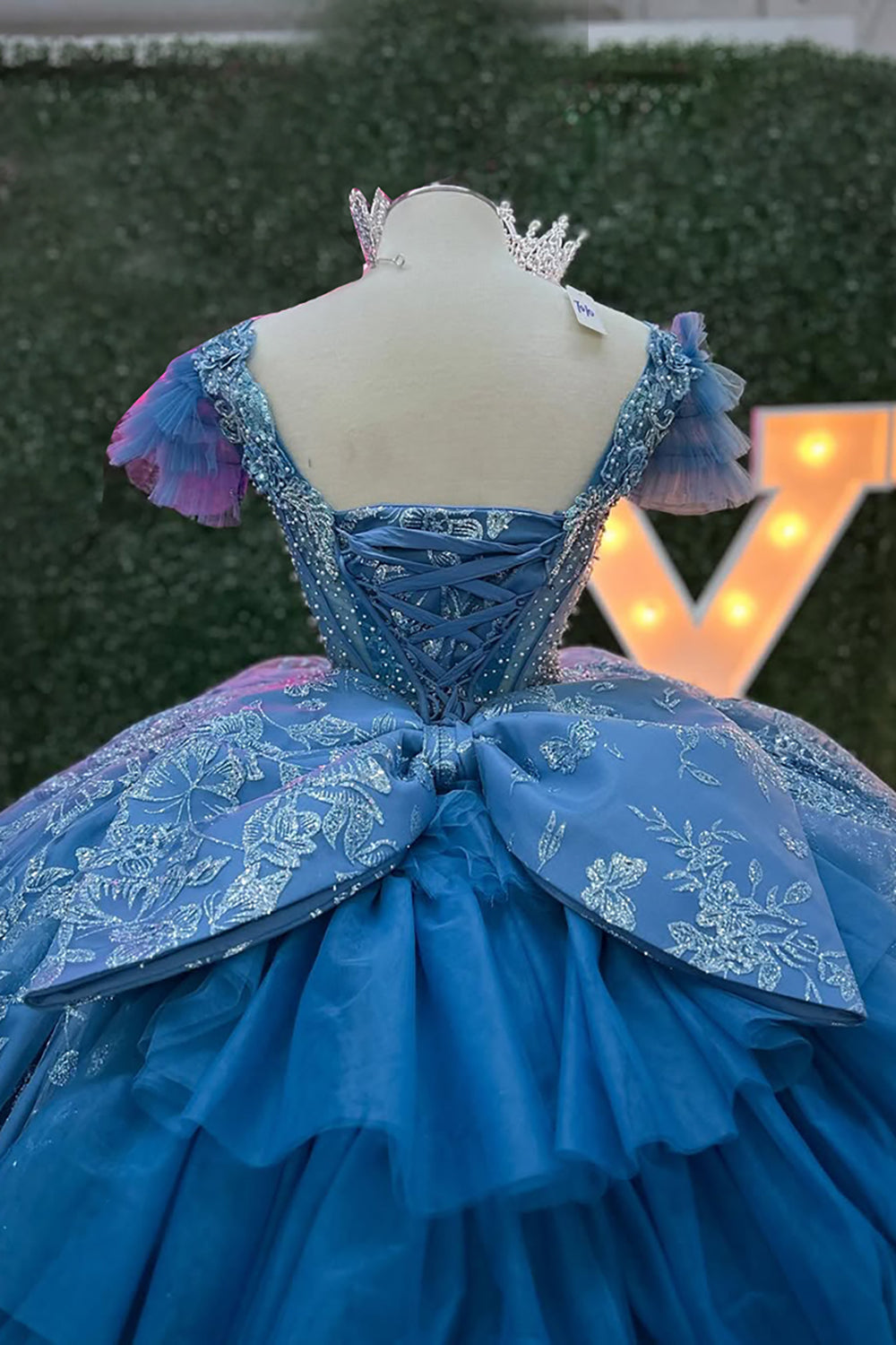 Robe de princesse grise et bleue à col en V, manches courtes et traîne, avec col en V et ornée d'appliqués.