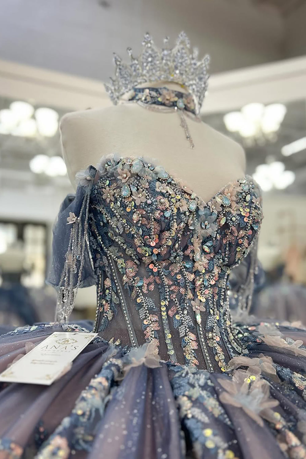 Robe de bal de quinceañera gris-bleu scintillante, épaules dénudées, ornée d'appliqués et avec traîne.