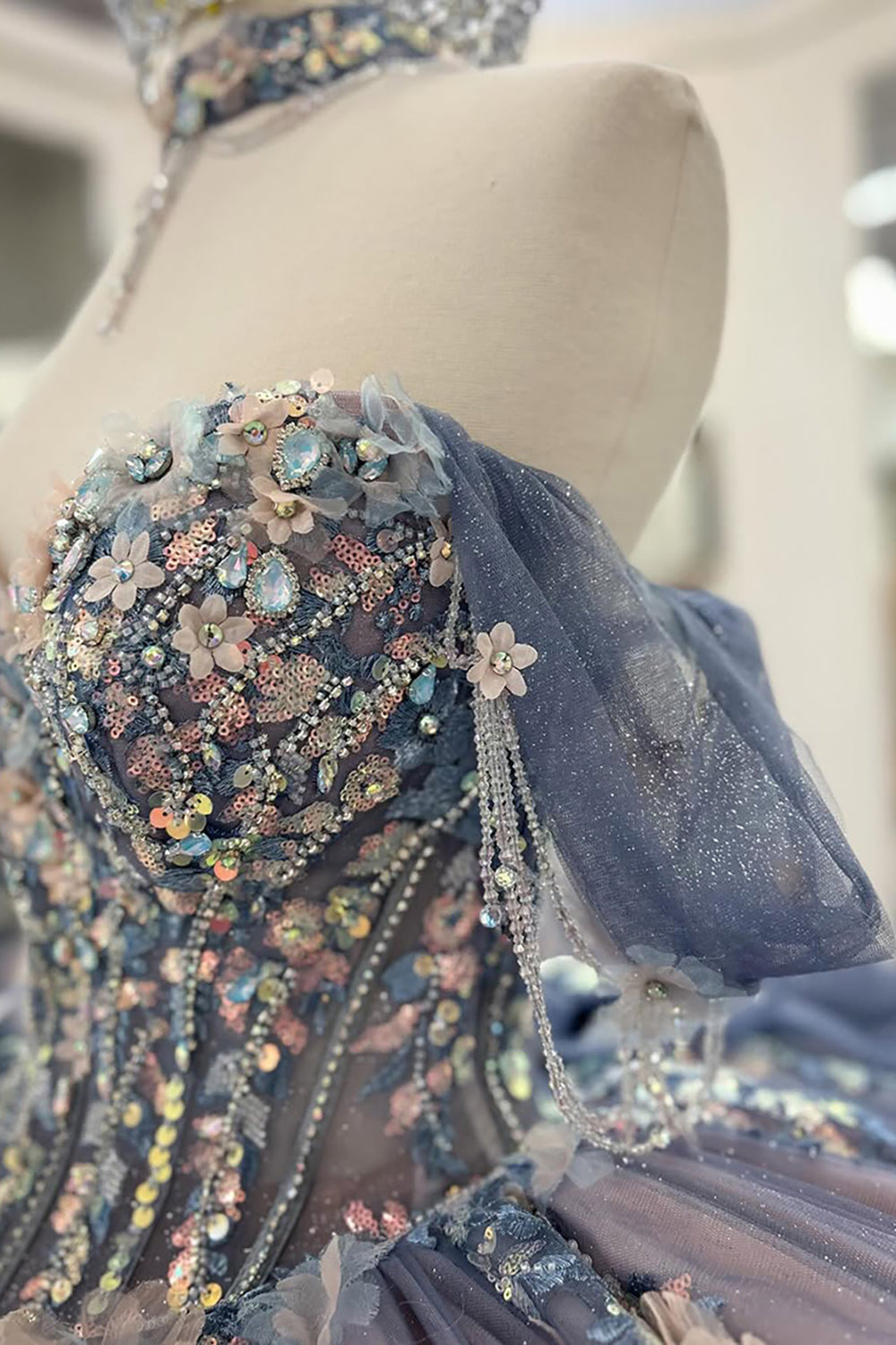 Robe de bal de quinceañera gris-bleu scintillante, épaules dénudées, ornée d'appliqués et avec traîne.