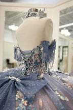 Robe de bal de quinceañera gris-bleu scintillante, épaules dénudées, ornée d'appliqués et avec traîne.