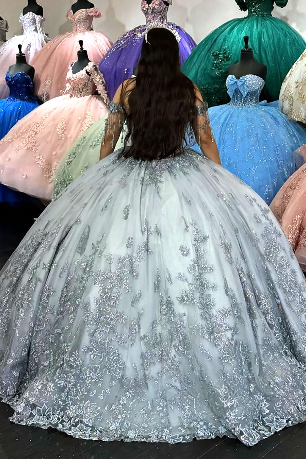 Vestido de quinceañera plateado brillante con hombros descubiertos, apliques de lentejuelas y flecos