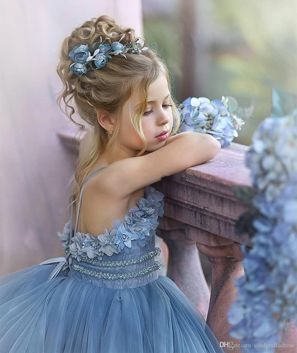 Vestido de niña de las flores de tul azul con tirantes finos y aplicaciones.