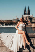 Robe de mariée longue blanche asymétrique sans manches, ornée de perles et fendue, qui me fait craquer.