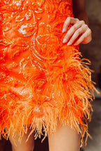 Vestido corto morado brillante de corte sirena con escote en V profundo y detalles de plumas.