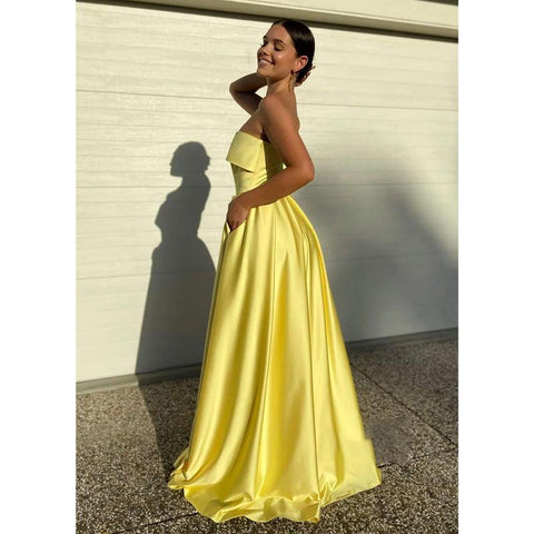 Vestido largo de fiesta amarillo satinado sin tirantes con abertura alta y bolsillos 