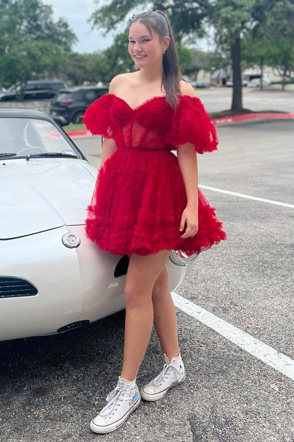 Robe de bal unique en tulle fuchsia, coupe trapèze, épaules dénudées et corset.
