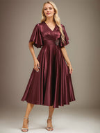 Vestido de novia de satén elástico, corte en A, escote en V, largo hasta la rodilla, con cuentas y pliegues. 