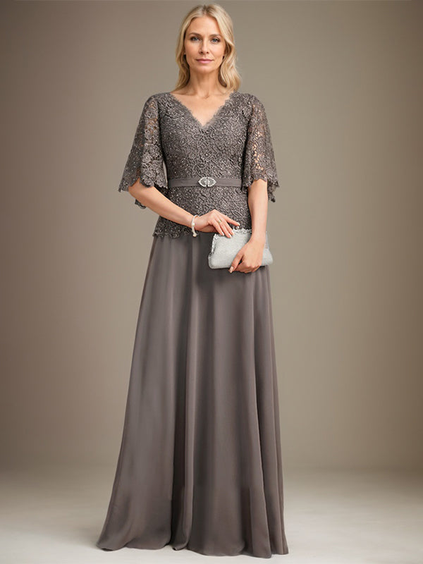 Vestido de novia de corte A, escote en V, largo hasta el suelo, de gasa y encaje, con broche de cristal y pedrería. 