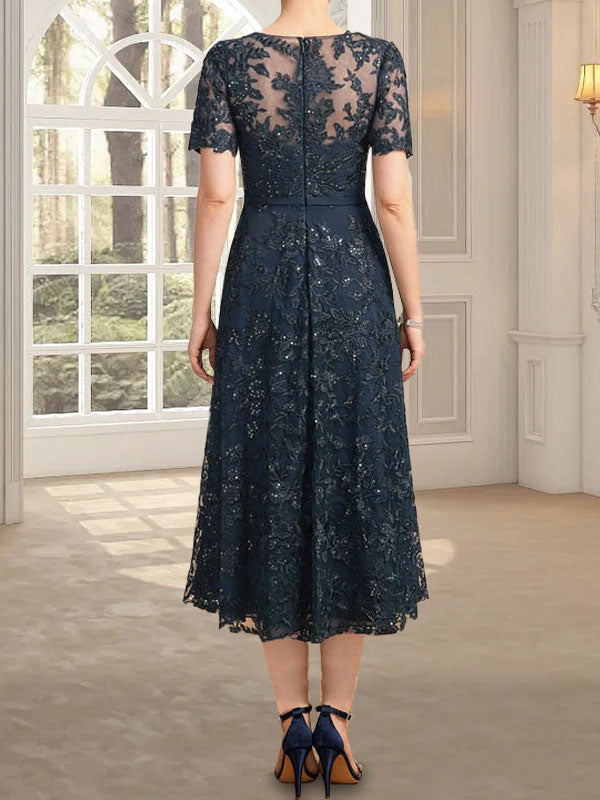 Vestido de novia de encaje con lentejuelas, corte en A, escote redondo ilusión y largo hasta la rodilla.