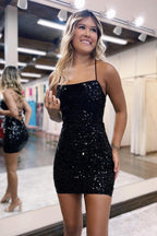 Robe de bal courte à paillettes noires, bretelles spaghetti et dos croisé, coupe fourreau scintillante.