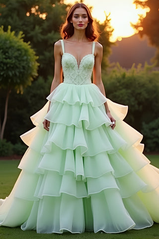 Vestido de gala largo verde con volantes y capas