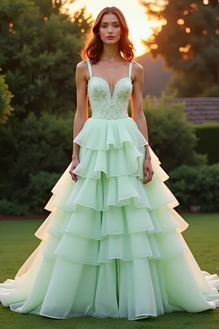 Vestido de gala largo verde con volantes y capas