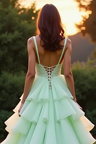 Vestido de gala largo verde con volantes y capas