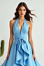 Vestido de fiesta azul de corte línea, escote halter, asimétrico, con volantes y bajo asimétrico.
