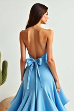 Vestido de fiesta azul de corte línea, escote halter, asimétrico, con volantes y bajo asimétrico.
