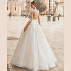 Vestido de novia con escote redondo, espalda ilusión, corte en A, tul, manga 3/4, apliques de encaje. 