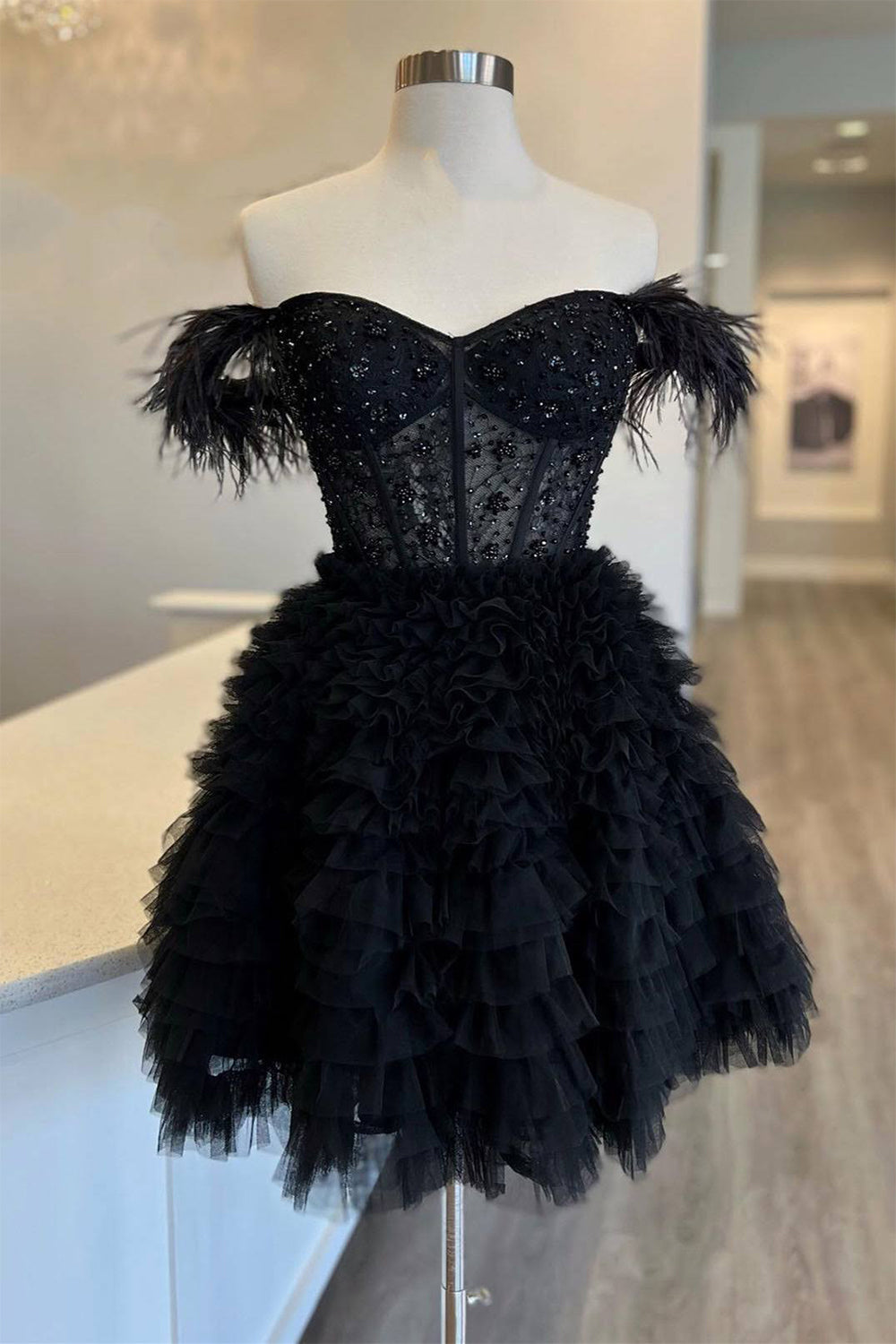 Un vestido corto rojo de fiesta con hombros descubiertos y plumas.