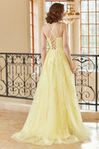 Magnifique robe de bal longue jaune à bretelles spaghetti et coupe trapèze, ornée d'appliqués.