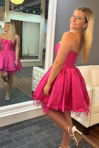 Elegante vestido corto fucsia de corte A con escote corazón y espalda cruzada para baile de bienvenida.