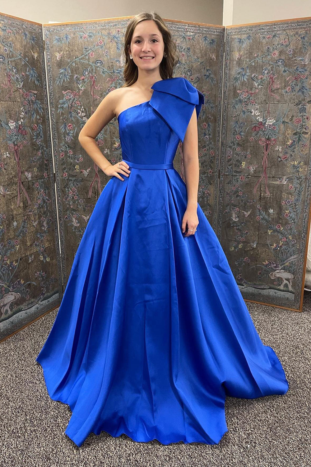Vestido largo de fiesta azul real de corte asimétrico con un solo hombro y lazo.
