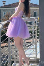 Vestido corto morado de corte línea con escote corazón y pedrería para baile de bienvenida.