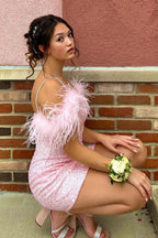 Robe fourreau courte rose à sequins et plumes, épaules dénudées, style robe de bal.