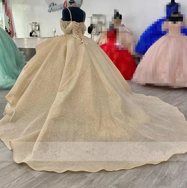 Vestido de quinceañera estilo princesa, color champán brillante, con elegantes tirantes y apliques. Modelo Y4150.