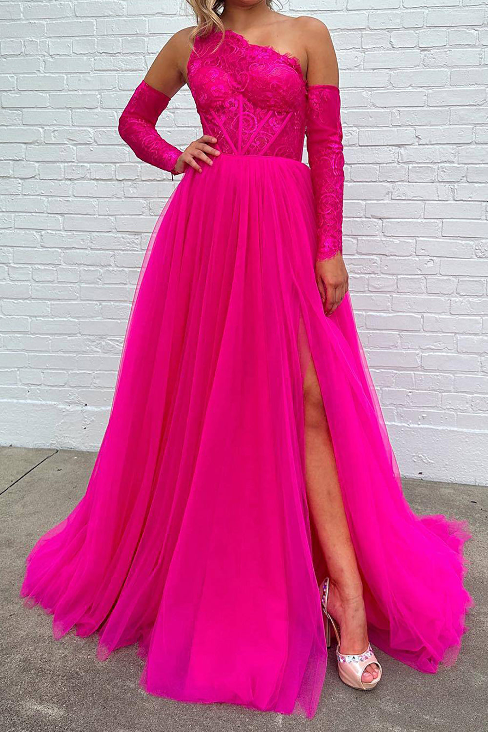 Vestido de fiesta fucsia de corte A, corte asimétrico, con corsé y abertura frontal.
