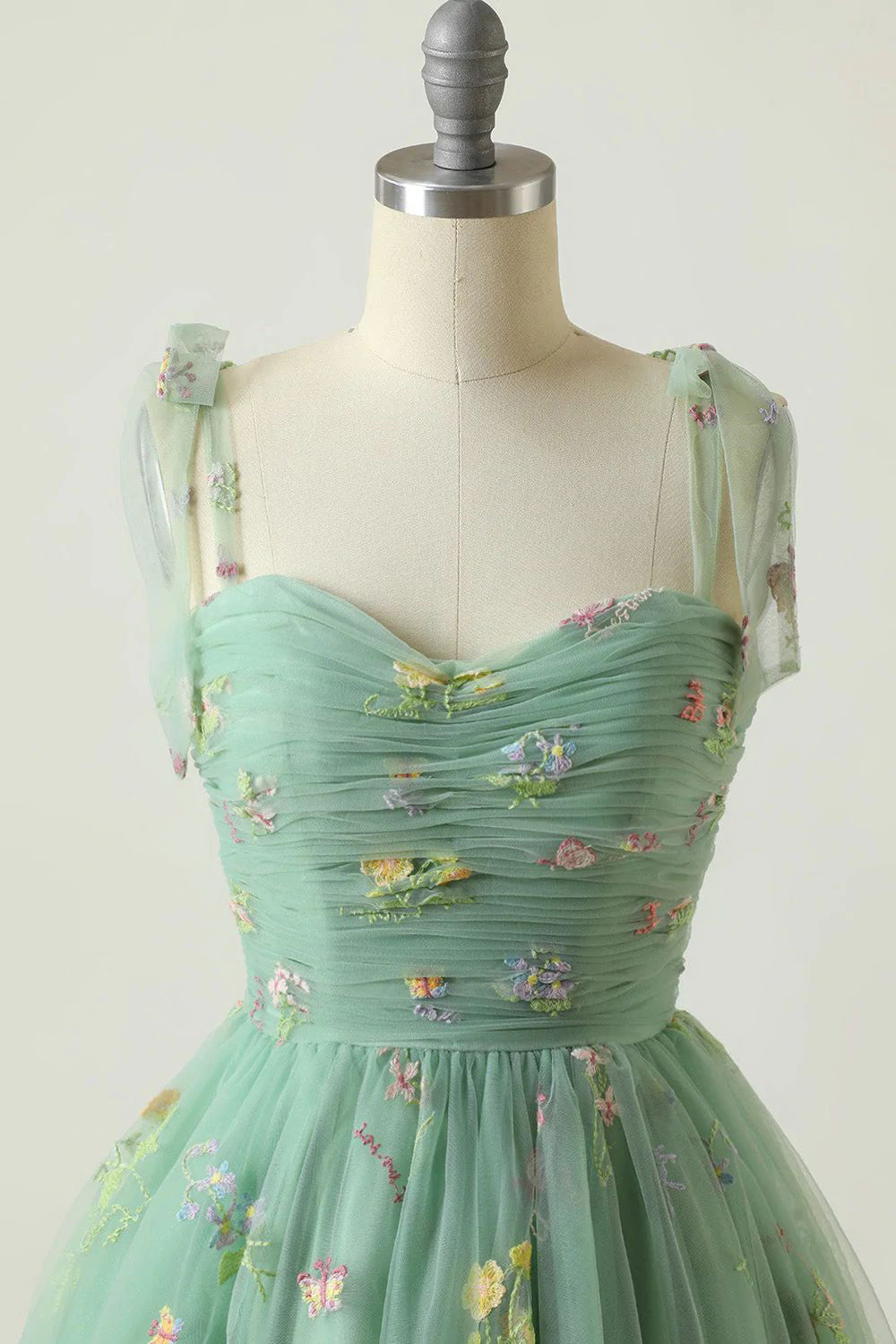 Robe de bal de promo champagne à fines bretelles et coupe trapèze, ornée de broderies.