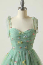 Robe de bal de promo champagne à fines bretelles et coupe trapèze, ornée de broderies.