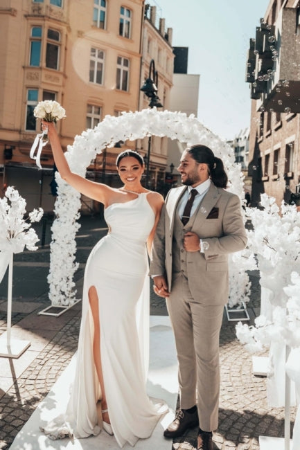 Robe de mariée longue blanche asymétrique sans manches, ornée de perles et fendue, qui me fait craquer.