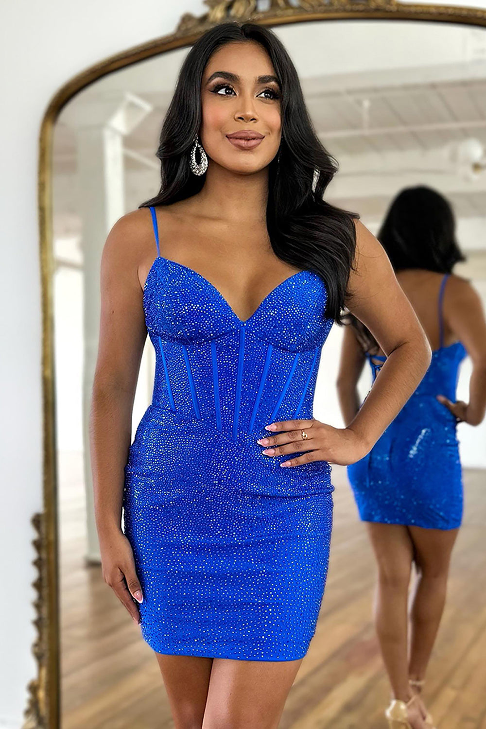 Robe de bal bleu marine à bretelles spaghetti et corset ornée de perles, fourreau scintillant.
