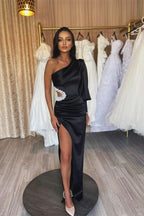 Robe de soirée asymétrique en satin noir à manches longues et fente plissée élégante, ornée d'une épaule.
