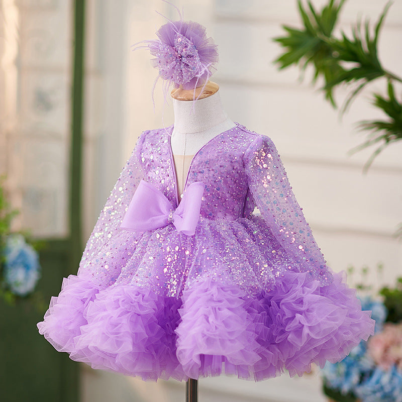 Vestido de bebé niña color lila con lentejuelas, mangas largas con volantes y lazo hasta la rodilla 