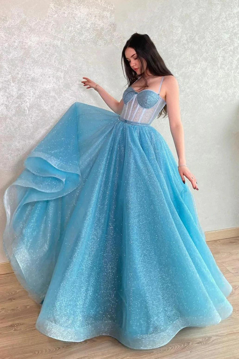 Robe de bal longue bleu clair à sequins, coupe trapèze, bretelles spaghetti et paillettes.