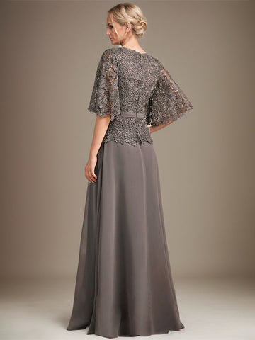 Vestido de novia de corte A, escote en V, largo hasta el suelo, de gasa y encaje, con broche de cristal y pedrería. 