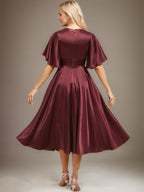 Vestido de novia de satén elástico, corte en A, escote en V, largo hasta la rodilla, con cuentas y pliegues. 