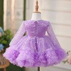 Vestido de bebé niña color lila con lentejuelas, mangas largas con volantes y lazo hasta la rodilla 