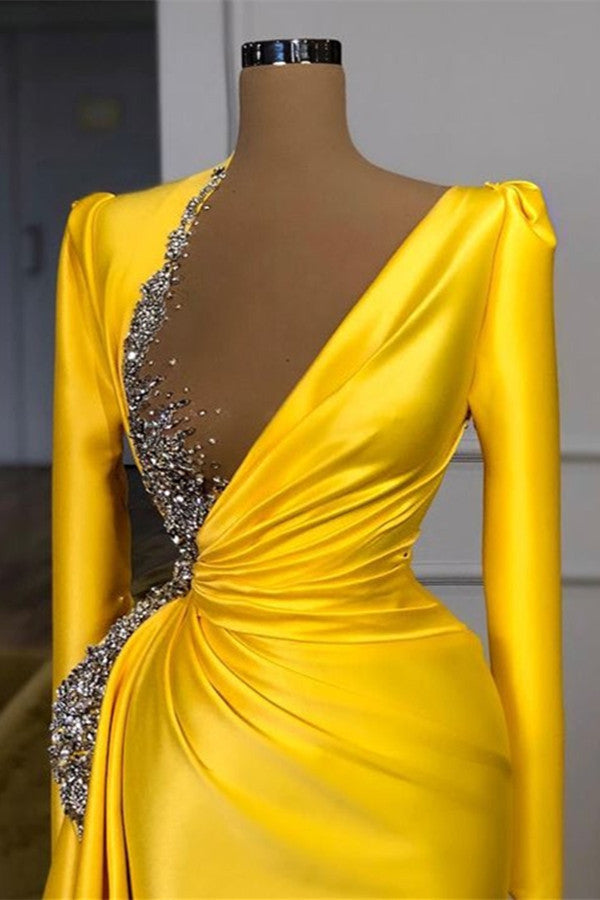 Vestido de fiesta amarillo de satén con mangas largas, escote en V y corte sirena, adornado con cuentas.
