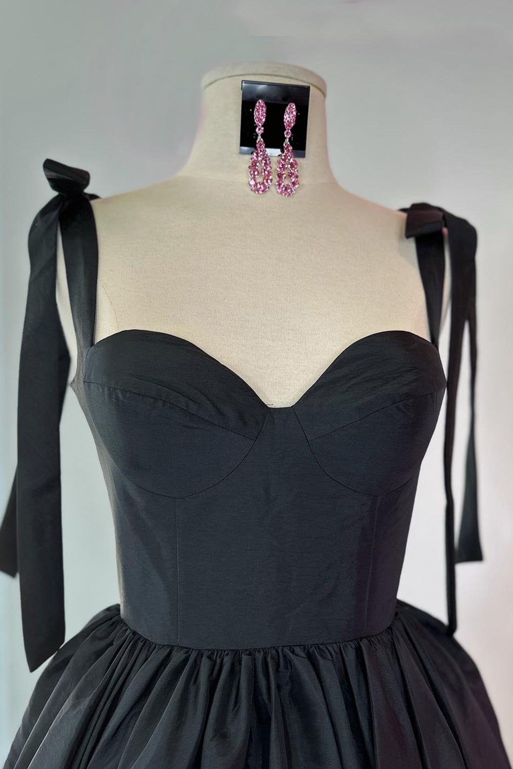 Robe de bal courte rose fuchsia à fines bretelles spaghetti et coupe princesse, ornée de fronces.