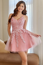 Robe de bal courte rose poudré à col V et coupe trapèze, ornée d'appliqués